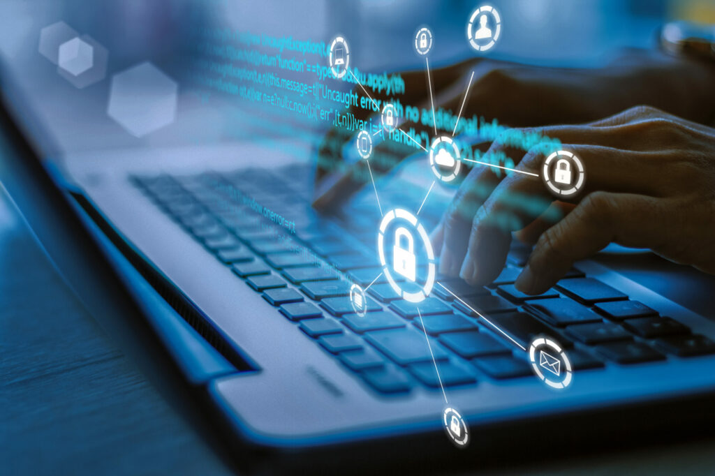 Business, technology, internet and networking concept. Young businesswoman working on his laptop in the office, select the icon security on the virtual display.