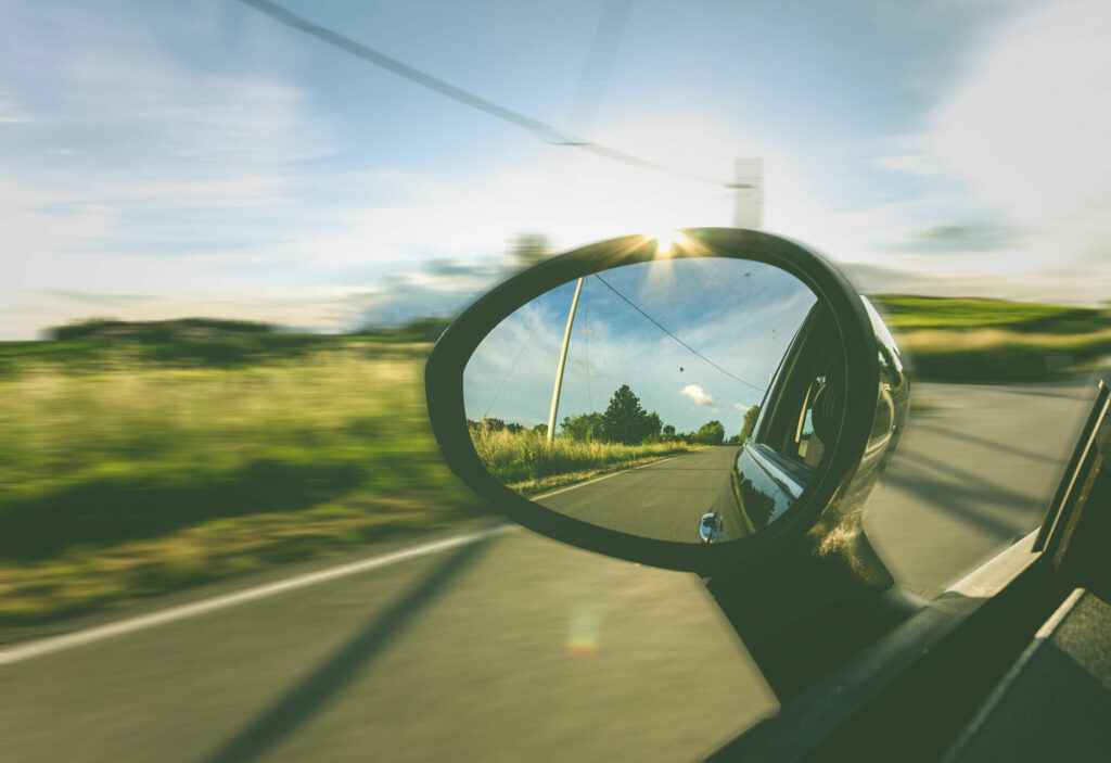 country road in rearview mirror