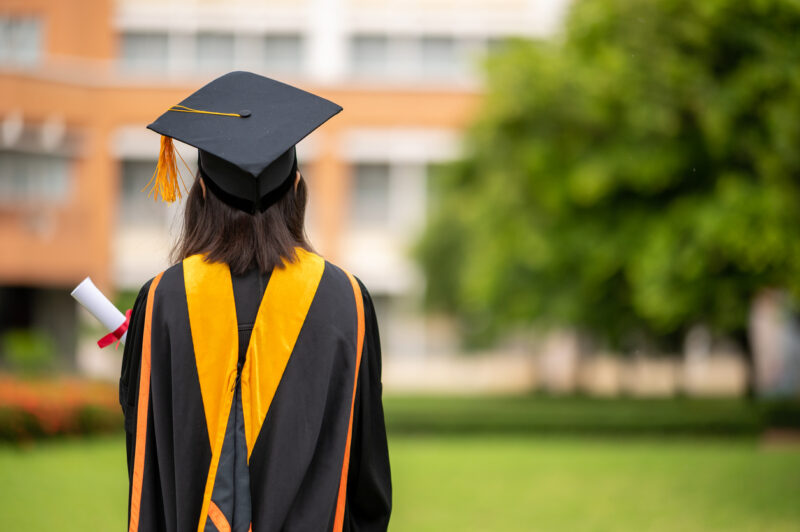 A graduate stands in-line while waiting for awarding degree certificate.