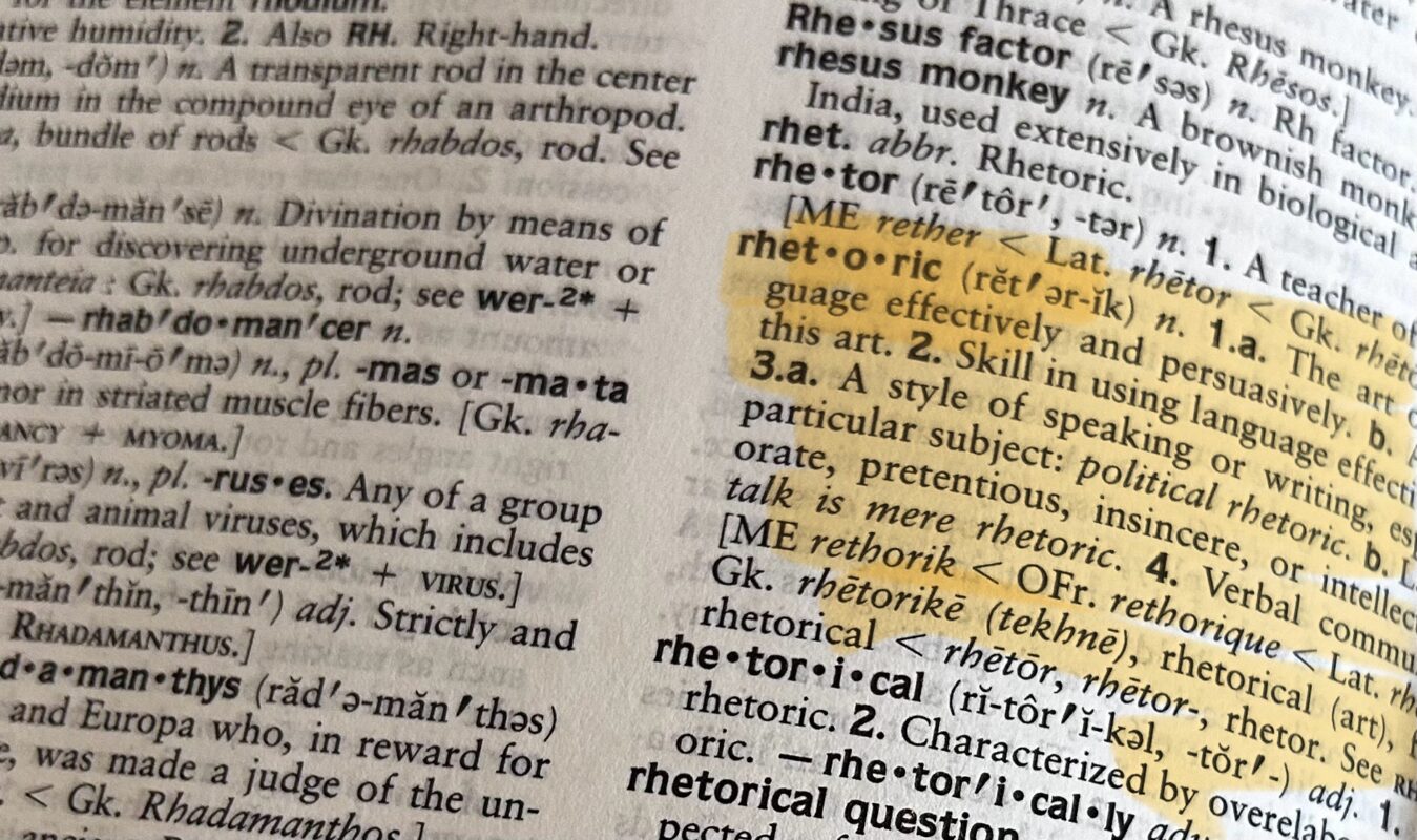 The word "rhetoric" in a dictionary, highlighted in yellow.