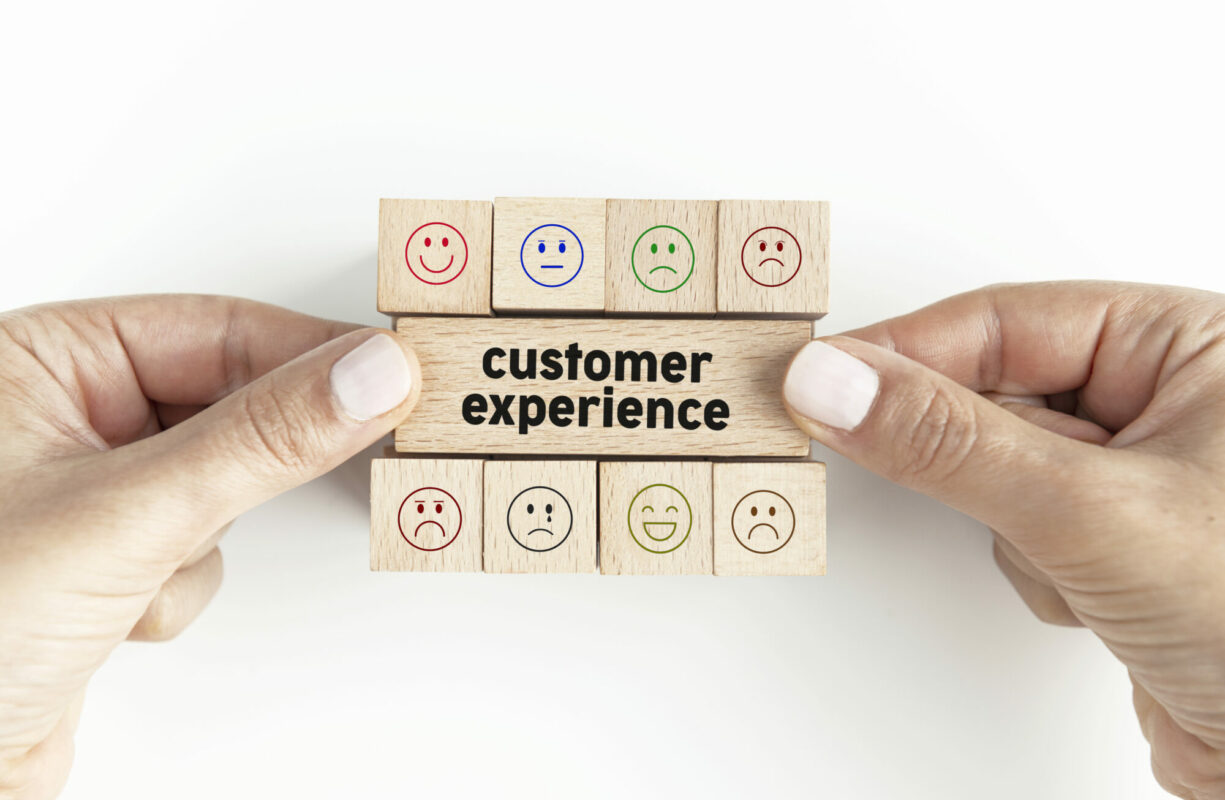 Wooden blocks that say "Customer Experience" held by two hands