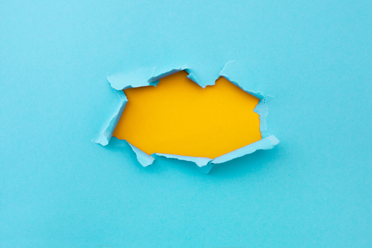 Torn hole in cardstock to suggest "breaking free."